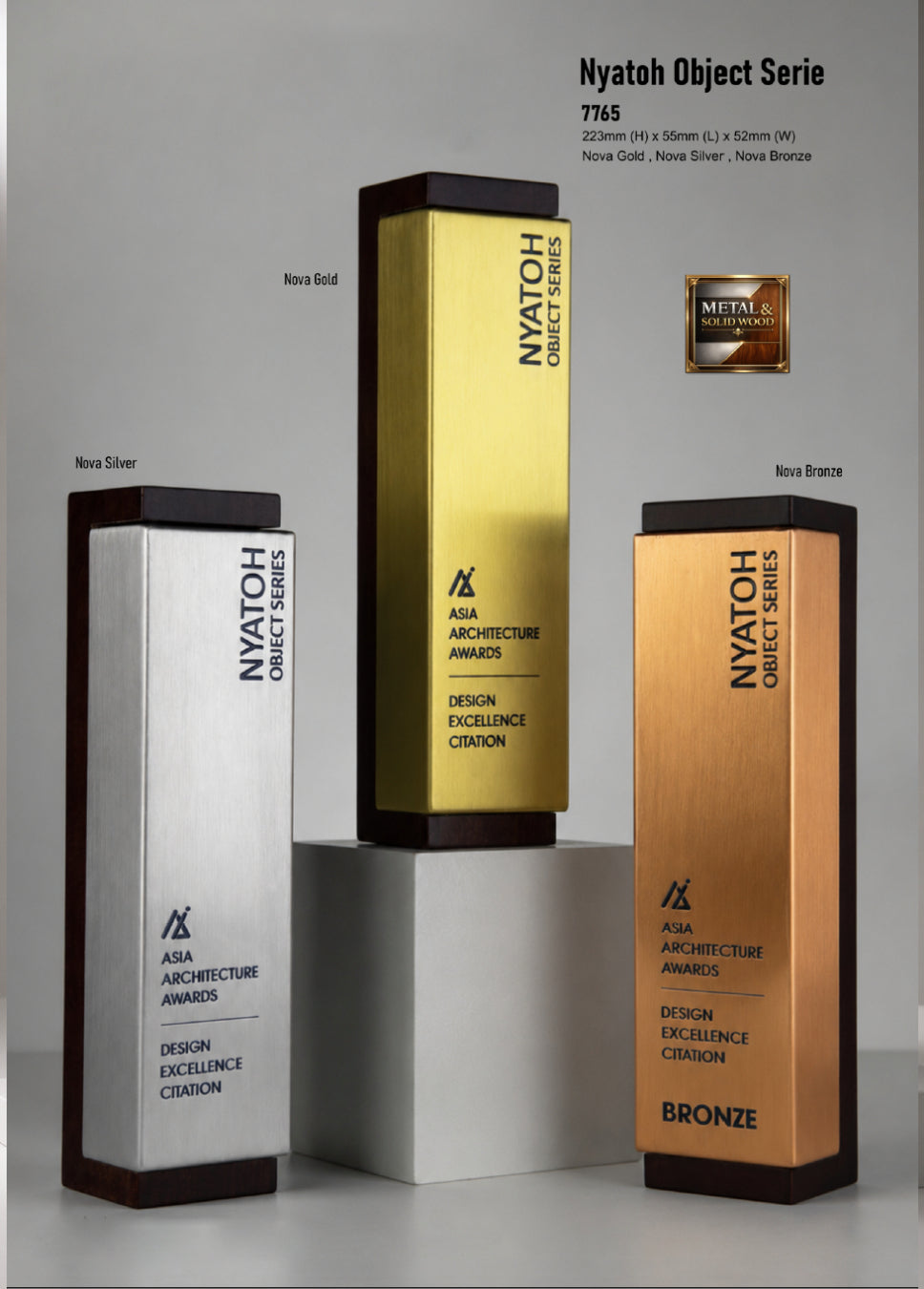 Three rectangular NYATOH Object Series award plaques in silver, gold, and bronze finishes displayed on pedestals against a light gray background, with product text and a small metallic badge above.